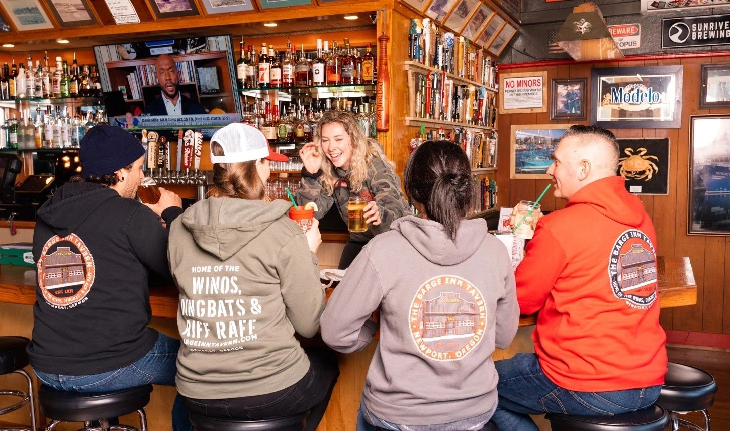 Barge Inn Tavern sports bar interior Newport Oregon — friends gathered at the bar